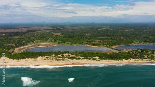 Coastline of Sri Lanka island with a beach and ocean. Tropical vegetation and agricultural land. photo