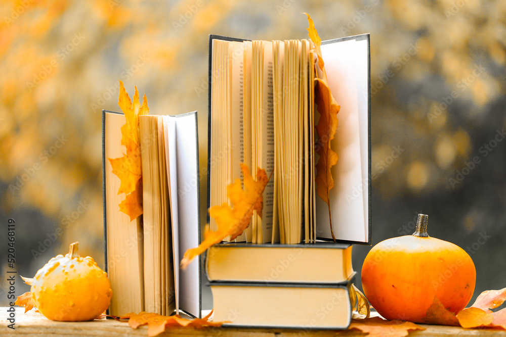 Books and pumpkins set in autumn garden with the rays of the sun.Start school and college season concept.Books on the autumn theme.Halloween Books.Back to school.Autumn thematic reading