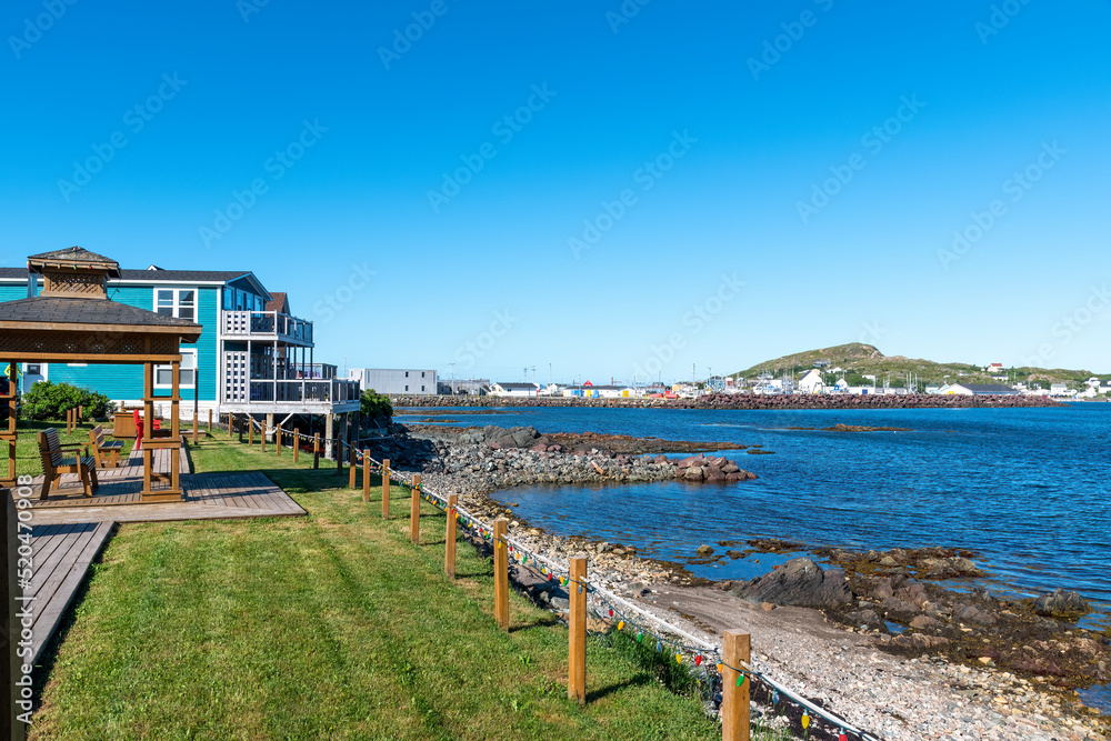 A view from a small picnic area at the shoreline of Twillingate, Newfoundland on a bright sunny day with a clear blue sky.