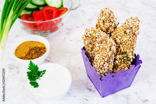Chicken fillet in oat flakes on white background