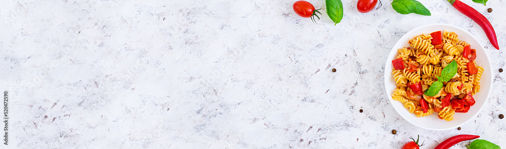 Radiatori pasta with chicken and peppers on white background. Top view. Banner. Radiatori pasta with chicken and peppers on white background. Top view. Banner.