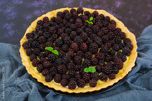 Delicious tart with blackberries on dark background