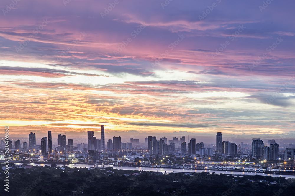Fototapeta premium Bangkok,Thailnad - Jul 23, 2022 : Gorgeous scenic of the sunrise or sunset with beautiful cloud and sky over large metropolitan city in Bangkok. Copy space, Selective focus.