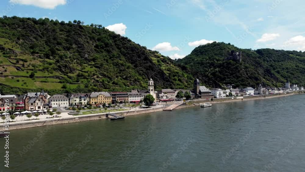 Aerial flying drone shot, tracking in, of the Rhine River Valley and Old Architecture - including medieval castles, old buildings, and natural forested alpine hills. Sunny day, clouds, and blue sky. Aerial flying drone shot, tracking in, of the Rhine River Valley and Old Architecture - including medieval castles, old buildings, and natural forested alpine hills. Sunny day, clouds, and blue sky.