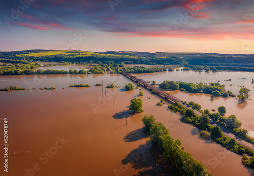 Flood on the Dniester River  Ivano-Frankivsk region. View from flying drone of car bridge among the flooded pastures and fields in western Ukraine. Disaster concept background.