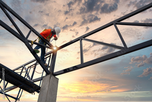 Steel roof truss welders with safety devices to prevent falls from a height in the construction site.