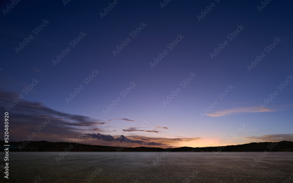 Empty asphalt floor with sunset sky