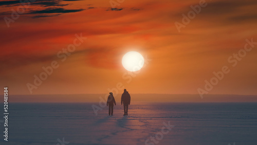 The two travelers with backpacks walking on a beautiful sunset background