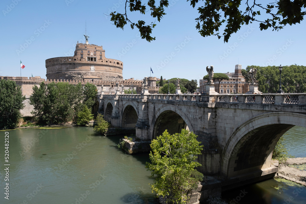 Ponte Sant'Angelo bridge with five arches statues of the angels and faced with travertine marbles in Rome, Italy. Cylindrical building of Castel Sant'Angelo or Mausoleum of Hadrian in background