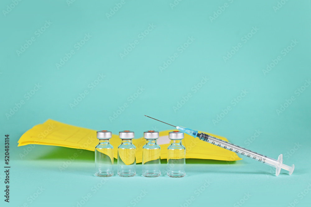 Corona booster vaccine concept with 4 vials with syringes and certificate of vaccination in background with copy space - obrazy, fototapety, plakaty 