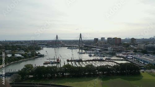 Cinematic aerial shot of Sydney City center in the morning, drone moving up over CBD revealing the beautiful Anzac Bridge, Sydney fish market and skyscrapers. photo