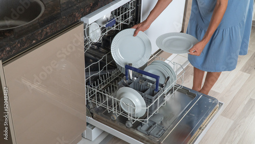 Wallpaper Mural A woman folds clean dishes from a dishwasher Torontodigital.ca