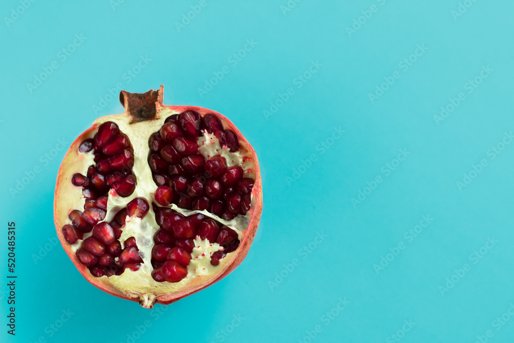Ripe fresh sliced pomegranate fruit isolated on blue background Ripe fresh sliced pomegranate fruit isolated on blue background