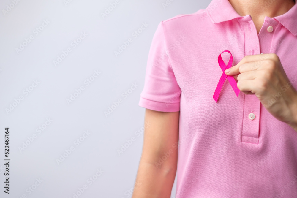 Pink October Breast Cancer Awareness month, woman hand hold pink Ribbon and wear shirt for support people life and illness. National cancer survivors month, Mother and World cancer day concept - obrazy, fototapety, plakaty 