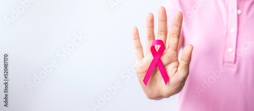 Pink October Breast Cancer Awareness month  woman hand hold pink Ribbon and wear shirt for support people life and illness. National cancer survivors month  Mother and World cancer day concept