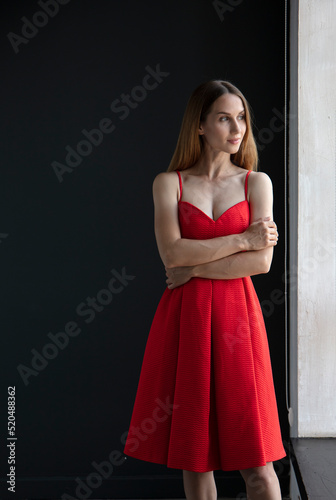 portrait of a beautiful young woman in a red dress, studio shot on a dark background