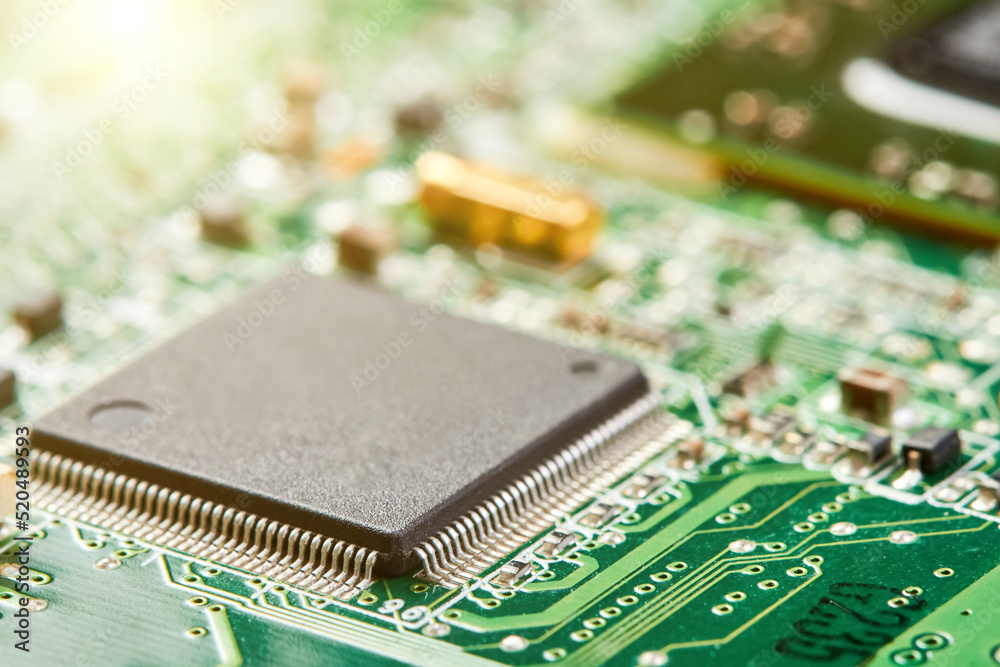 Close-up of computer chip on a part of electronic printed circuit board with sunlight Close-up of computer chip on a part of electronic printed circuit board with sunlight