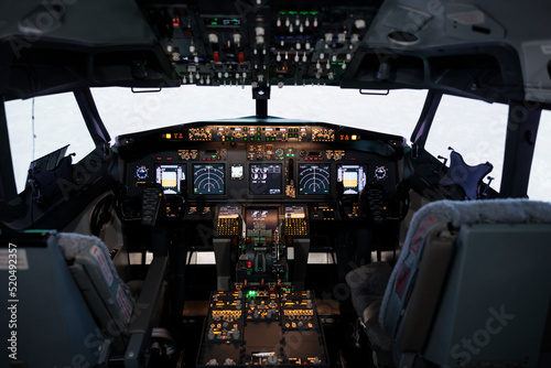 Nobody in airplane cockpit with electronic flying navigation panel, control command with buttons and lever on dashboard. No people in aircraft cabin to throttle engine and takeoff.
