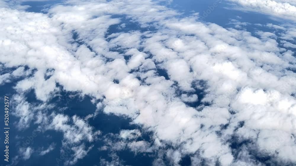 Selective focus of 4k video Flying over clouds. View from plane, thinning of ozone layer concept, freshness and environment concept, ecology. Aerial view of clouds with the blue sky above surface eart Selective focus of 4k video Flying over clouds. View from plane, thinning of ozone layer concept, freshness and environment concept, ecology. Aerial view of clouds with the blue sky above surface eart