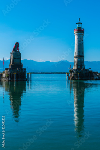 Germany, Lindau city port lighthouse and beautiful view to austria and bregenz alsp mountains reflecting in silent bodensee lake water photo