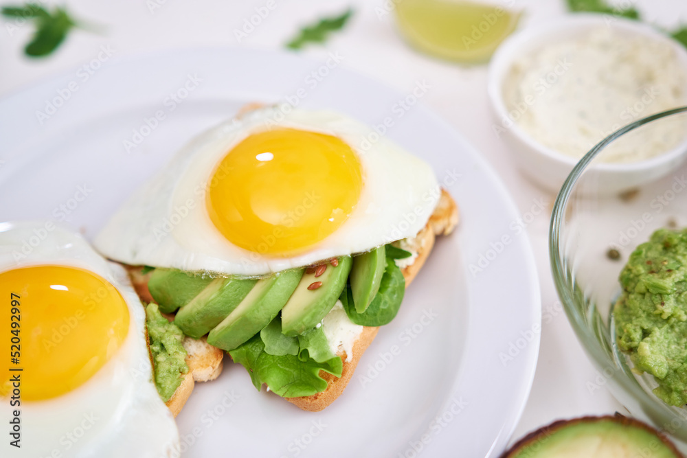 healthy breakfast or snack - sliced avocado and fried egg on toasted bread healthy breakfast or snack - sliced avocado and fried egg on toasted bread