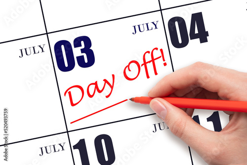 3rd day of July. Hand writing text DAY OFF and drawing a line on calendar date 3 July. Vacation planning concept. Summer month, day of the year concept.