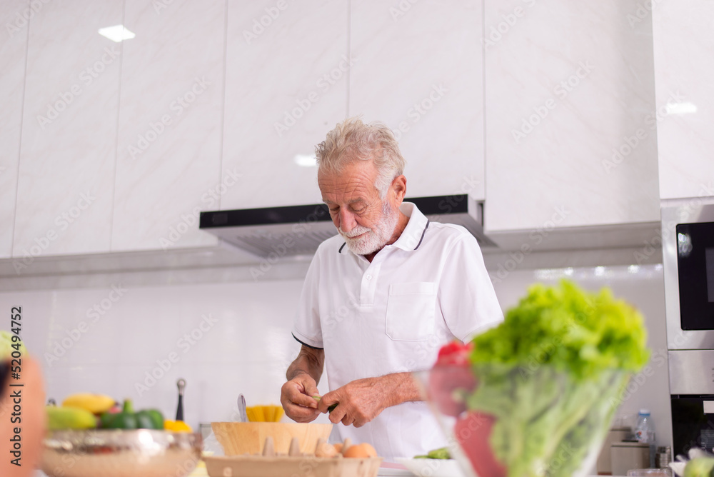 Senior man cooking meal at home in the morning,Elderly healthy food concept,Preparing breakfast Senior man cooking meal at home in the morning,Elderly healthy food concept,Preparing breakfast