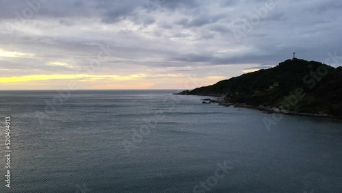 An aerial shot of sunset over a tropical beach with palms and green mountain, Haad Rin, Koh Pangan, Thailand photo