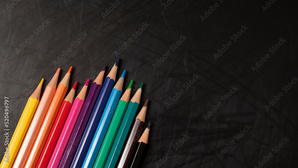 different color wooden pencils on black chalkboard background different color wooden pencils on black chalkboard background