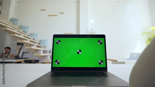 Wallpaper Mural Young woman studies online via modern laptop with green chromakey screen. Open electronic device stands on white table in office close view Torontodigital.ca