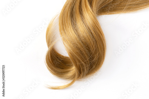 Long blond curly hair on white background. A part of blond hair for design.