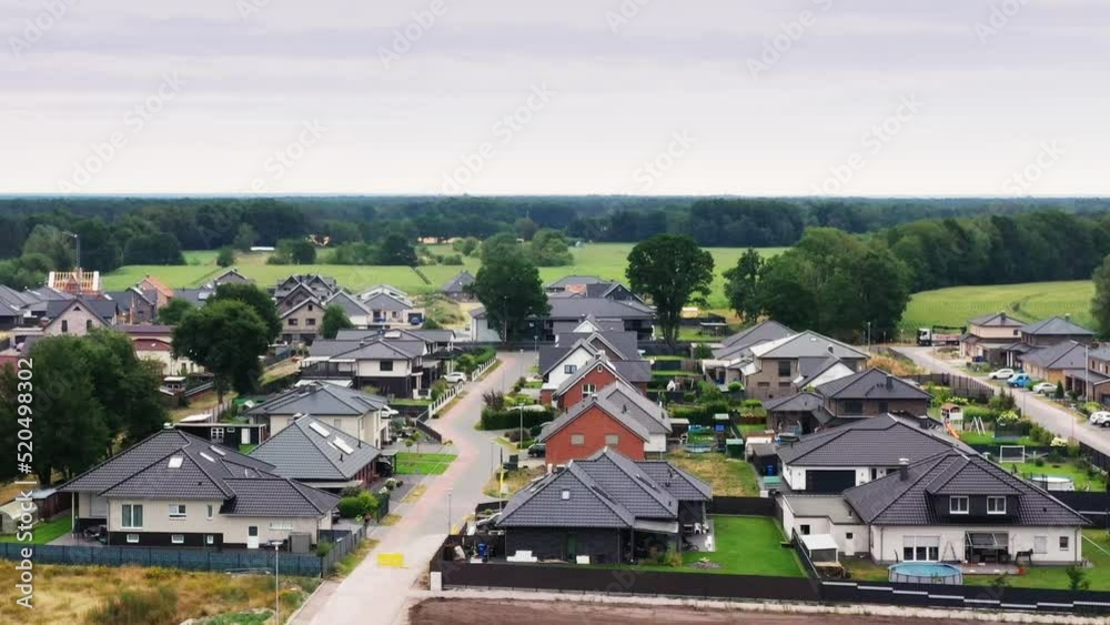 Aerial view of a new development with fancy single-family homes and remnants of a construction site facility on the edge Aerial view of a new development with fancy single-family homes and remnants of a construction site facility on the edge