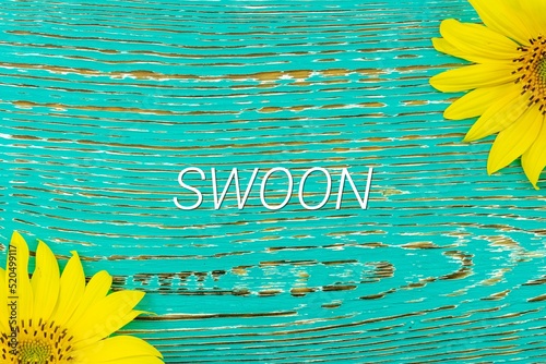 SWOON - text, yellow flowers, sunflowers, wooden background (copy space). photo