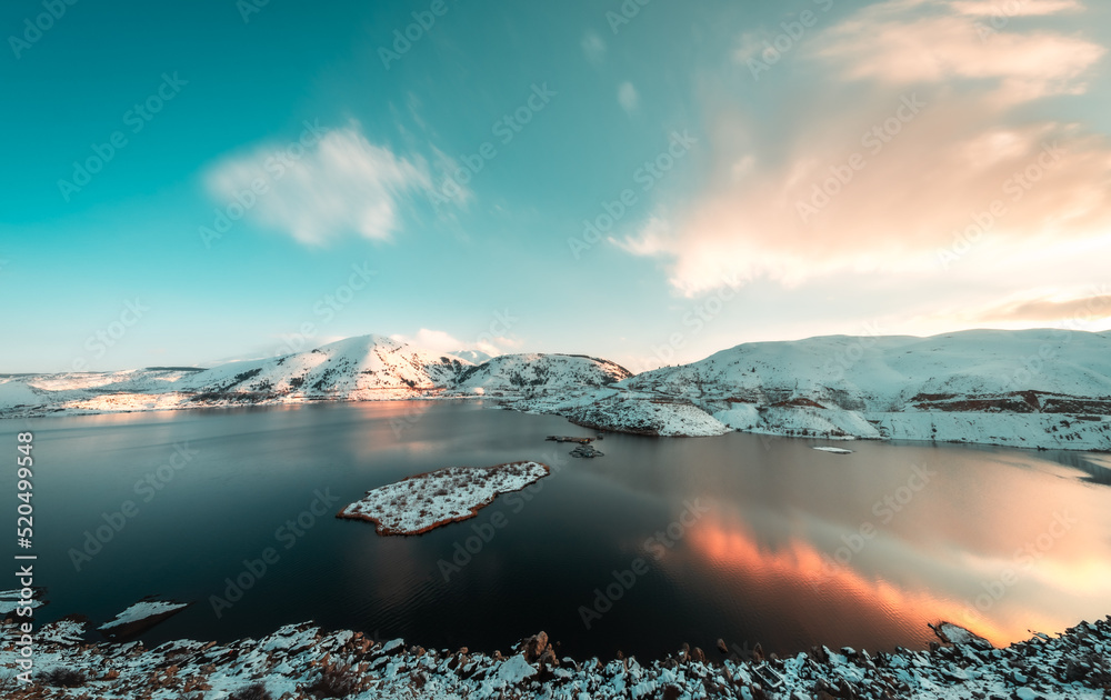 Snowy and lake view in winter, sunset in the evening. motion blur and long exposure