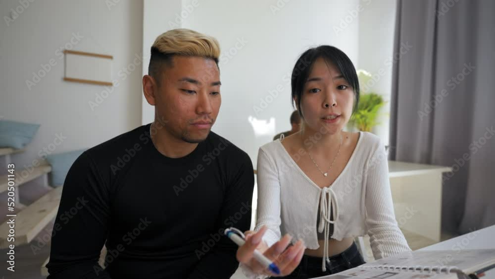 POV of Asian man with dyed hair helping Asian brunette woman conduct online video conference sitting at desk in office. Colleagues present new project closeup POV of Asian man with dyed hair helping Asian brunette woman conduct online video conference sitting at desk in office. Colleagues present new project closeup