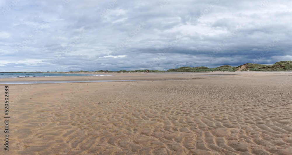 panorama landscape of Doughmore Beach in County Clare at low tide with sand dunes in the background