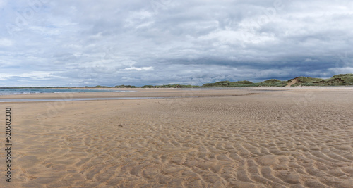 panorama landscape of Doughmore Beach in County Clare at low tide with sand dunes in the background