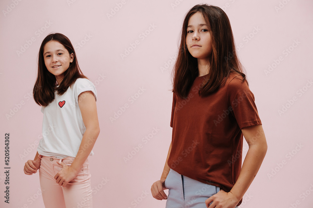Portrait of two confident twin girls dressed in different colors posing Portrait of two confident twin girls dressed in different colors posing
