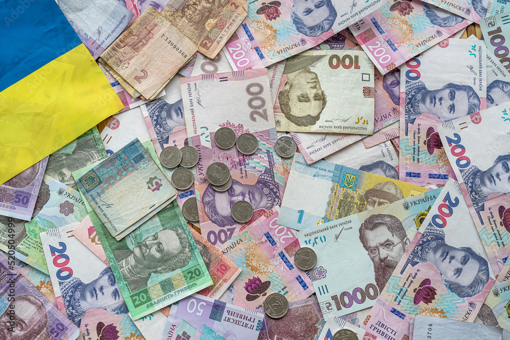 Ukrainian money paper bills wit hcoin on national flag, top view Ukrainian money paper bills wit hcoin on national flag, top view