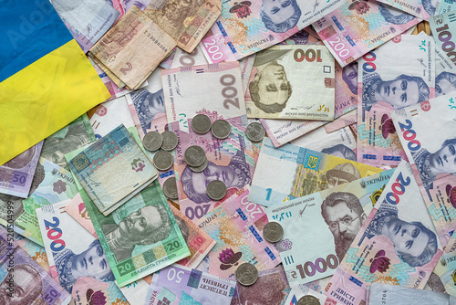 Ukrainian money paper bills wit hcoin  on national flag  top view