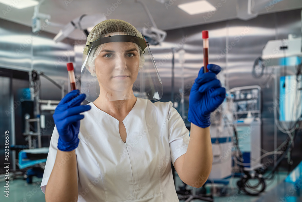 nurse doctor in protective uniform glove and mask looks at blood samples in operating hospital nurse doctor in protective uniform glove and mask looks at blood samples in operating hospital