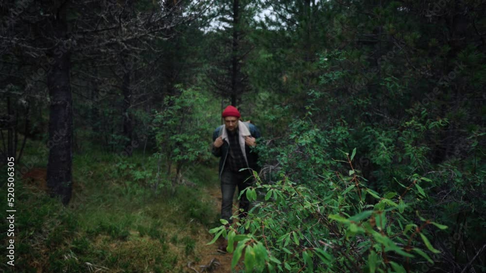 Tourist traveler with backpack in denim sherpa walks along forest path. Travel summer concept with vintage style hipster travel Tourist traveler with backpack in denim sherpa walks along forest path. Travel summer concept with vintage style hipster travel