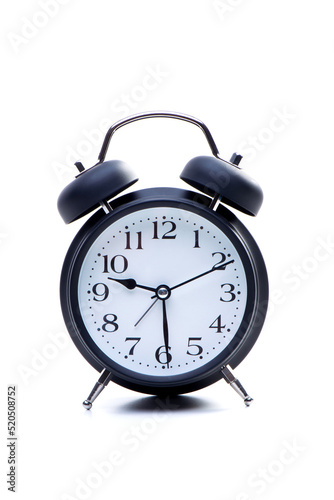Alarm clock isolated on white background. Round clock shows daytime work time or evening bedtime