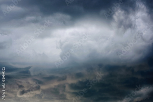 Storm clouds in the sky. Stormy sky background with gray clouds before rain. Weather forecast concept. Dark thunderstorm clouds and shining clouds, cloudscape. Stormcloud in the sky. Blur effect