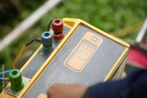 Technician using the old equipment and Earth resistance tester. photo