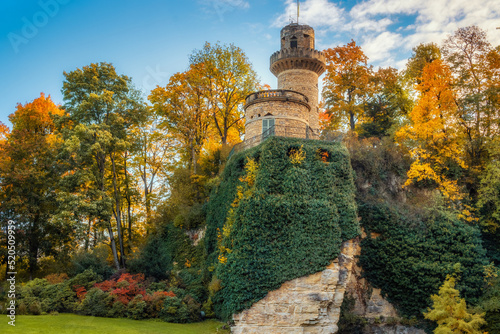 View on a fairytale tower on a rock surrounded by colourful trees in autumn