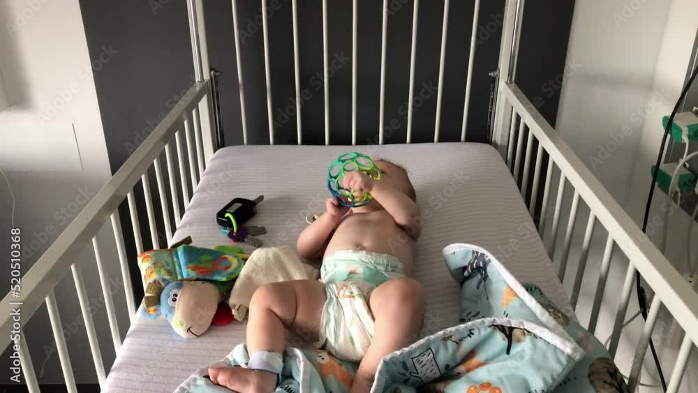 Baby playing in her bed with her baby toys.
