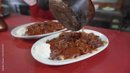 Turkey Iskender kebab. 
Pouring sauce on meat.

