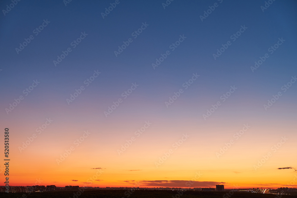 Gradient of orange-blue evening sky without clouds at sunset