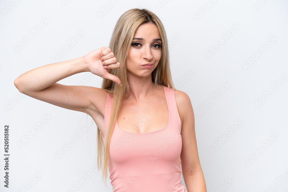 Pretty blonde woman isolated on white background showing thumb down with negative expression Pretty blonde woman isolated on white background showing thumb down with negative expression
